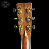 Close-up of a guitar headstock with tuning pegs on a black background, featuring the Tone Shop logo.
