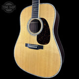 Acoustic guitar with a visible brand logo on a black background