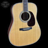 Acoustic guitar with a visible brand logo on a black background