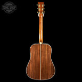 Acoustic guitar with a visible brand logo on a black background