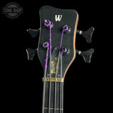 Close-up of a bass guitar headstock with a 'W' logo on a black background, featuring the Tone Shop branding.