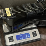 Electric guitar on a digital scale displaying weight