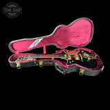 Gibson guitar in a pink case with 'Tone Shop' logo in the corner.