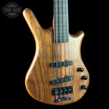 Wooden bass guitar with a black background, featuring the Tone Shop logo.