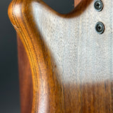 Close-up of a guitar's wooden neck and body with a clear finish.