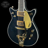 Gretsch electric guitar with gold hardware on a black background