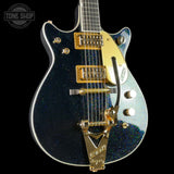 Electric guitar with blue glitter finish and gold hardware on a black background