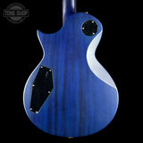 Blue electric guitar with a close-up of the body on a black background, featuring the Tone Shop logo.