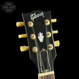 Gibson guitar headstock with tuning pegs on a black background