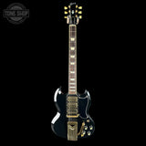 Electric guitar with a black finish and gold hardware on a white background