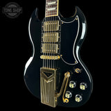 Black electric guitar with gold hardware on a black background, featuring 'Tone Shop' logo.