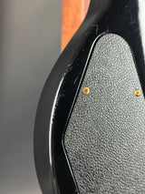 Close-up of a textured black surface with gold screws.