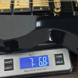 Guitar on a digital scale displaying weight