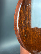 Close-up of a wooden surface with visible grain and imperfections on a dark background