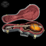 Mandolin in a black case with red interior, Tone Shop logo visible