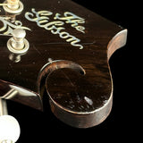 Close-up of a guitar's soundhole with 'The Gibson' branding.