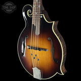 Mandolin with a dark brown finish on a black background, featuring the Tone Shop logo.