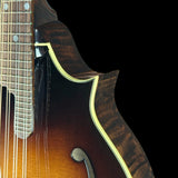 Close-up of a mandolin with a dark brown finish on a black background