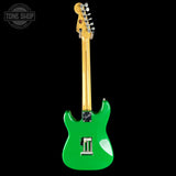 Green electric guitar with a gold neck on a black background, featuring 'Tone Shop' logo.