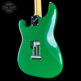 Green electric guitar with a visible brand logo on a black background