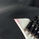 Close-up of a mechanical keyboard key with a black and white design on a dark background