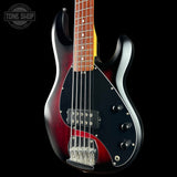 Electric bass guitar with a red and black finish on a black background, featuring the Tone Shop logo.