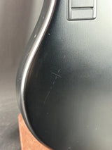 Close-up of a black plastic component with a metal handle on a gray background