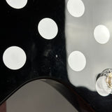 Close-up of a black and white polka dot pattern with a clear object on the right.