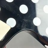 Close-up of a black metal object with circular patterns on a white background