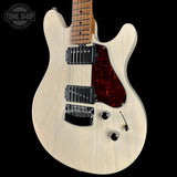 Electric guitar with a white pickguard and red tortoiseshell pickguard on a black background, featuring the Tone Shop logo.