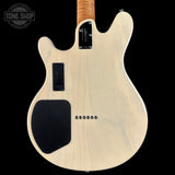 Back view of a bass guitar with a 'Tone Shop' logo in the corner.