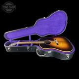 Acoustic guitar in a black case with purple interior on a black background, featuring 'Tone Shop' logo.