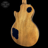 Wooden guitar body with a black pickguard on a black background, featuring 'Tone Shop' logo.