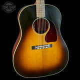 Acoustic guitar with a sunburst finish on a black background, featuring the Tone Shop logo.