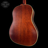 Back view of a wooden acoustic guitar with 'Tone Shop' logo in the corner.