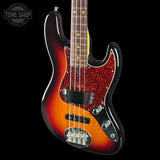 Electric bass guitar with a sunburst finish on a black background, featuring the Tone Shop logo.