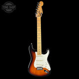 A classic Fender Stratocaster electric guitar in a sunburst finish, featuring a white pickguard and maple neck, shown against a solid black background with a Tone Shop watermark in the top left corner.