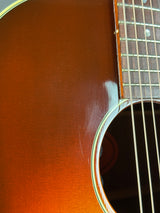 Close-up of a brown acoustic guitar with a focus on the soundhole.