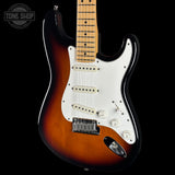 A classic electric guitar with a sunburst finish, featuring a white pickguard, chrome hardware, and a maple neck, shown against a solid black background.