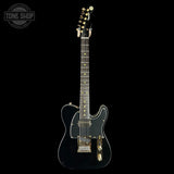 Black electric guitar on a black background with 'Tone Shop' logo.