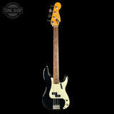 A classic four-string bass guitar with a black body, cream pickguard, and a natural wood neck and headstock, shown against a solid black background.