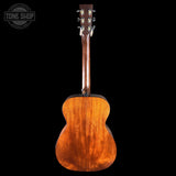 Back view of a wooden acoustic guitar on a black background with 'Tone Shop' logo.
