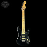A black Fender Stratocaster electric guitar with a natural maple neck and headstock, shown against a solid black background. A 'TONE SHOP' watermark is visible in the top-left corner.
