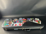 Black guitar case with various stickers on a dark background