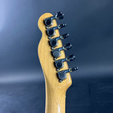 Guitar headstock with tuning pegs on a dark background