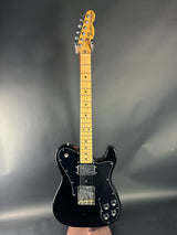 Black electric guitar on a gray background