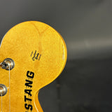 Close-up of a guitar's pickguard with 'Sting' branding on a dark background