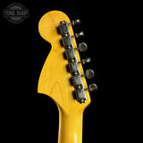 Close-up of a guitar headstock with tuning pegs on a black background, featuring the Tone Shop logo.