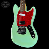 Electric guitar with a red pickguard and light green body on a black background, featuring 'Tone Shop' branding.