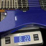 A close-up of a blue electric guitar body resting on a digital scale, showing the scale display reading 8.22 lbs and the brand name 'Workin'' visible on the device.